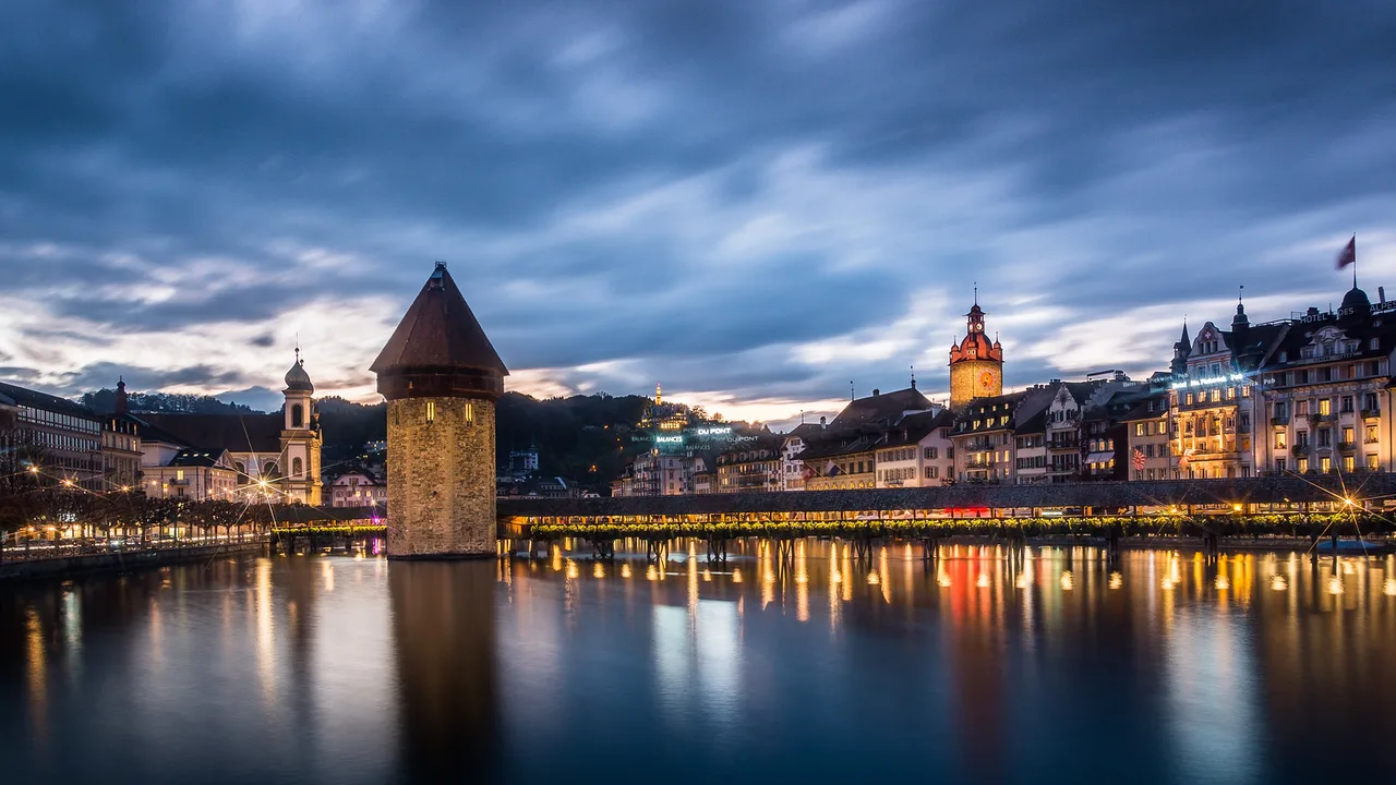 Chapel Bridge (Kapellbrücke) in Lucerne at blue hour, illuminated over the Reuss River.